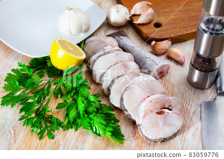 Sliced fresh raw hake with greens, lemon and spices 83059776