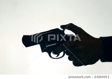 Silhouette of man's hand with revolver on white background. 83060953