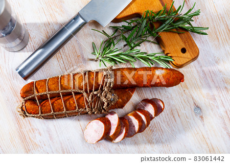 Sliced half-smoked sausages on wooden table Sliced half-smoked sausages on wooden table 83061442