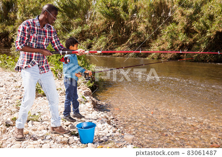 Man and boy fishing with rods 83061487