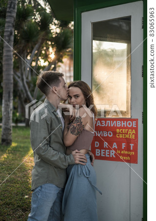 Couple in love standing on the street, cuddling and kissing. Wearing casual clothes. High quality photo Couple in love standing on the street, cuddling and kissing. Wearing casual clothes. High quality photo 83065963
