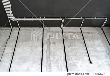 Electrical cables and pipes on house concrete wall and ceiling Electrical cables and pipes on house concrete wall and ceiling 83066759