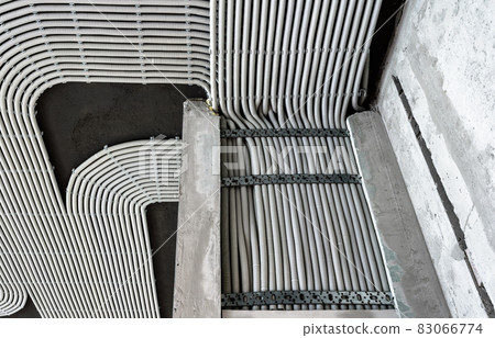 Electrical cables and pipes on house concrete wall and ceiling Electrical cables and pipes on house concrete wall and ceiling 83066774