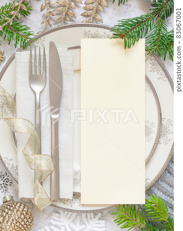 Festive table setting of with fir tree branches and Christmas decorations. Menu card mockup Festive table setting of with fir tree branches and Christmas decorations. Menu card mockup 83067001