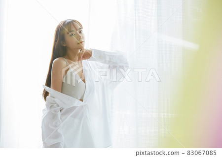 Natural beauty portrait of a young woman standing by the window Natural beauty portrait of a young woman standing by the window 83067085