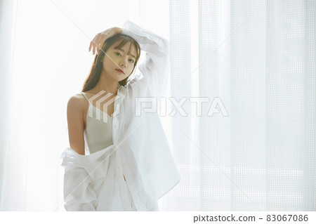 Natural beauty portrait of a young woman standing by the window Natural beauty portrait of a young woman standing by the window 83067086