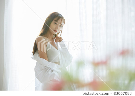 Natural beauty portrait of a young woman standing by the window Natural beauty portrait of a young woman standing by the window 83067093