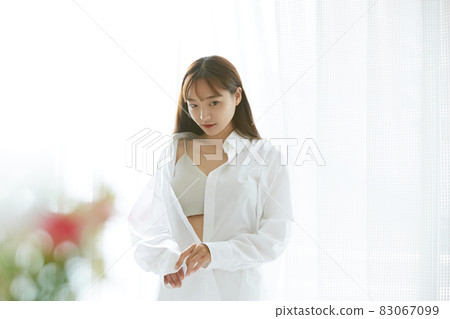 Natural beauty portrait of a young woman standing by the window 83067099