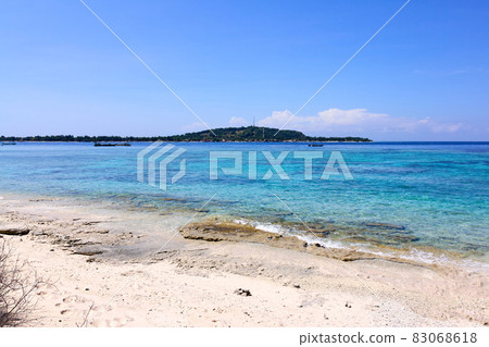 Tropical Asian beach with white sand, turquoise ocean against blue sky with clouds Tropical Asian beach with white sand, turquoise ocean against blue sky with clouds 83068618