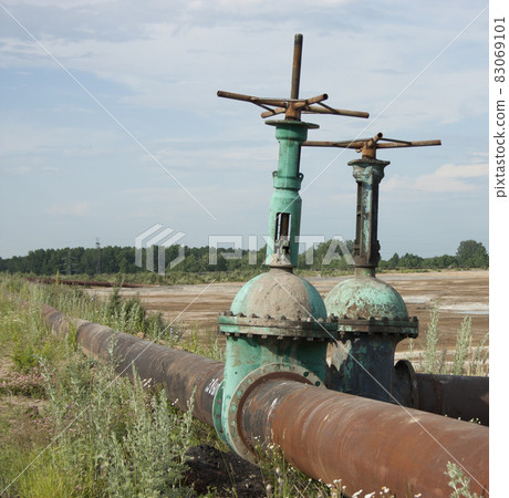 Two large valves for waste pipes in the open air. Sunny day, blue sky Two large valves for waste pipes in the open air. Sunny day, blue sky 83069101