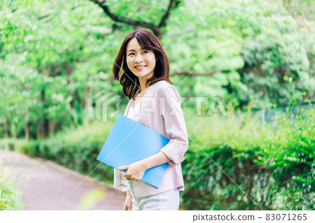 Young business woman walking with documents Young business woman walking with documents 83071265