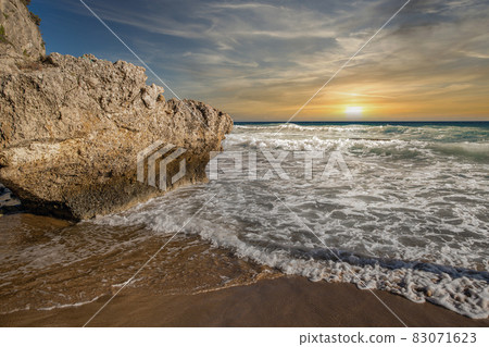 Fantastic sunset seascape with waves crashing onto rocks. Corfu, Greece. Fantastic sunset seascape with waves crashing onto rocks. Corfu, Greece. 83071623