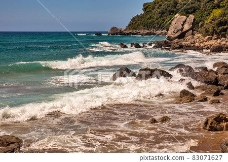 Sea waves crashing onto rocks with water splashes. Corfu island, Greece. Sea waves crashing onto rocks with water splashes. Corfu island, Greece. 83071627
