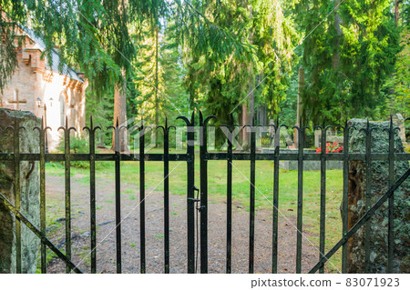 Fence at old semetery in Finland with grave crosses and stones. 83071923