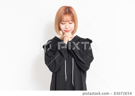 A young woman in casual clothes making a request gesture 83072654