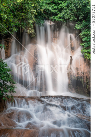 Beautiful Sai Yok Noi waterfall flowing on limestone in tropical rainforest at Kanchanaburi 83072711