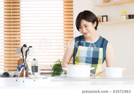 A woman recording a cooking video in the kitchen A woman recording a cooking video in the kitchen 83072963