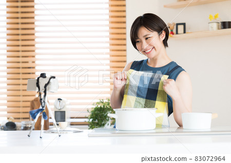 A woman recording a cooking video in the kitchen A woman recording a cooking video in the kitchen 83072964