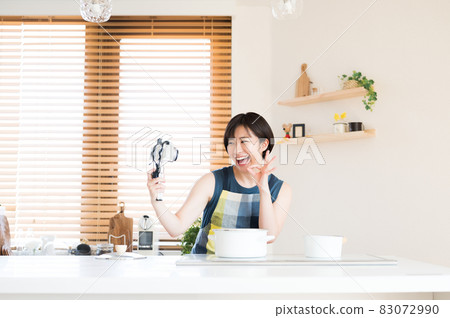 A woman recording a cooking video in the kitchen A woman recording a cooking video in the kitchen 83072990
