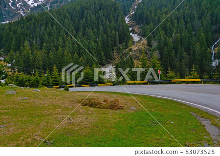 Picturesque mountain winding road against the background of a green forest. 83073528