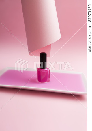 Pink nail polish dipped in pink liquid and pink background. Aesthetic and minimalism concept. Pink nail polish dipped in pink liquid and pink background. Aesthetic and minimalism concept. 83073986