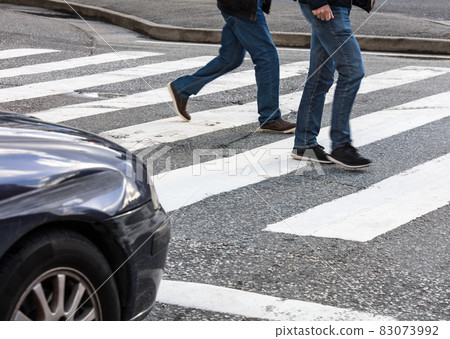 pedestrian crossing and car at crossroads 83073992