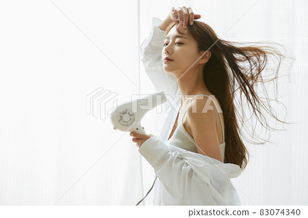 Young woman drying her hair 83074340