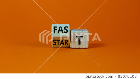 Time to fast start symbol. Turned a wooden cube with words 'fast start'. Beautiful orange table, orange background, copy space. Business and fast start concept. 83076108