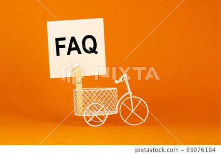 FAQ, frequently asked questions symbol. White paper. Words 'FAQ, frequently asked questions'. Miniature bicycle. Beautiful orange background. Business and FAQ concept, copy space. 83076184