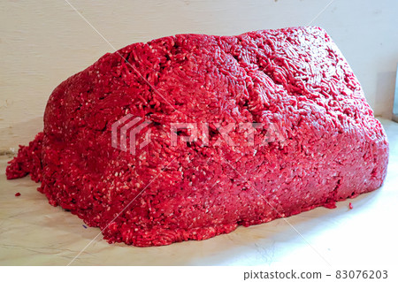 A large pile of ground moose meat on a white table A large pile of ground moose meat on a white table 83076203