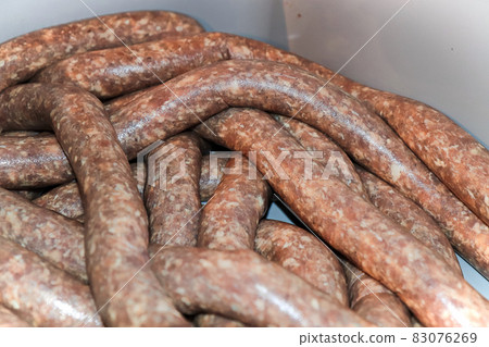 Closeup of raw sausage in casings resting in a tub Closeup of raw sausage in casings resting in a tub 83076269
