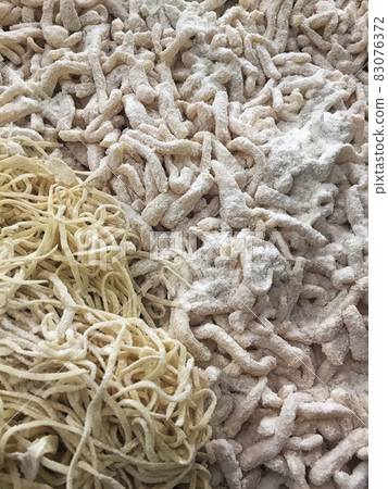Closeup of freshly homemade floured pasta pieces 83076372