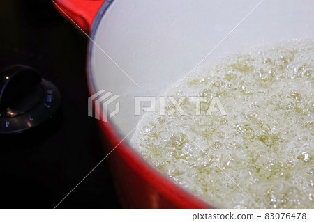 Closeup of liquid boiling in a pot 83076478