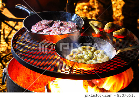 A surf and turf meal being cooked on a campfire A surf and turf meal being cooked on a campfire 83076513