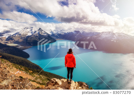 Adventurous Caucasian Woman hiking on top of a Canadian mountain. Adventurous Caucasian Woman hiking on top of a Canadian mountain. 83077270