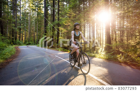 Adventurous Woman Bike Riding on a Trail in Forest Adventurous Woman Bike Riding on a Trail in Forest 83077293