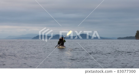 Adventurous Woman on Sea Kayak paddling in the Pacific Ocean. Adventurous Woman on Sea Kayak paddling in the Pacific Ocean. 83077300