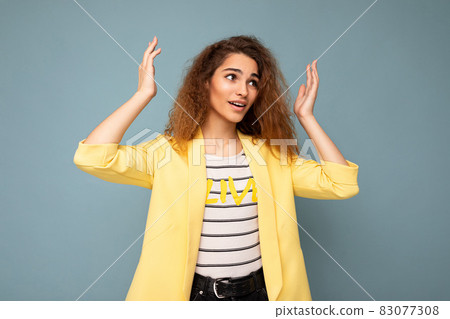 Photo shot of young emotional attractive brunette curly woman with sincere emotions wearing trendy Photo shot of young emotional attractive brunette curly woman with sincere emotions wearing trendy 83077308