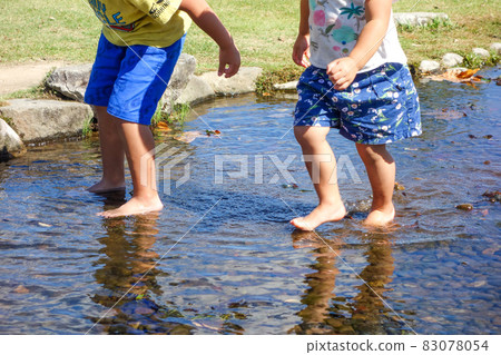 Children playing in the shallow river [River play image] 83078054