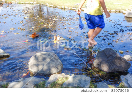 Children playing in the shallow river [River play image] 83078056