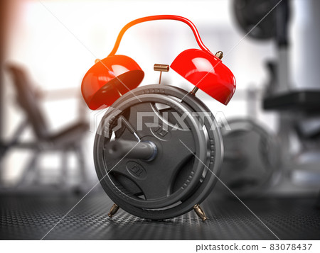 Barbell discs and alarm clock in gym.  Time for workout gym concept. 83078437