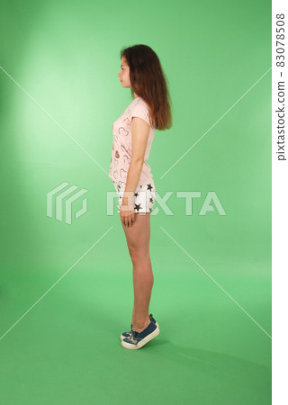 Side view young girl with long hair looking at wall. 83078508