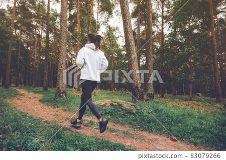 Woman running in autumn forest. Exercising outdoors Woman running in autumn forest. Exercising outdoors 83079266