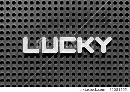 White alphabet letter in word lucky on black pegboard background White alphabet letter in word lucky on black pegboard background 83081565