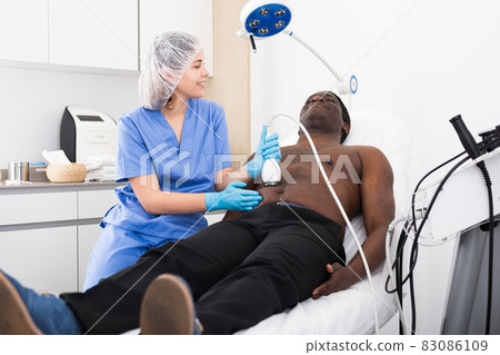 american man having cavitation procedure in beauty clinic 83086109