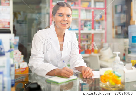 Pharmacist standing behind counter 83086796