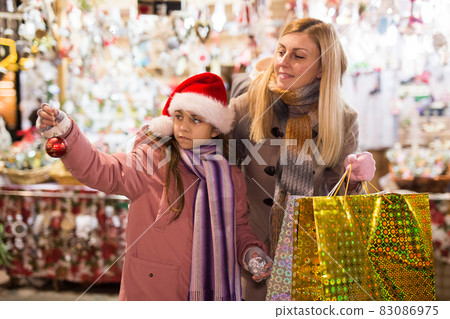 Mother with daughter choosing Christmas decoration Mother with daughter choosing Christmas decoration 83086975