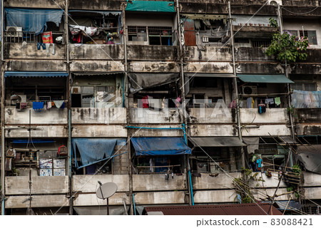 Geometrical pattern of multistory apartment house with group of windows and tenant lumber on balconies, Social problems in overcrowded countries Geometrical pattern of multistory apartment house with group of windows and tenant lumber on balconies, Social problems in overcrowded countries 83088421