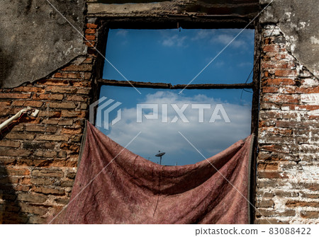Brick wall and a old window overlooking the sky in the ruins of the old building. Brick wall and a old window overlooking the sky in the ruins of the old building. 83088422