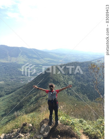 一個女人在山頂上張開雙手 一個女人在山頂上張開雙手 83089413